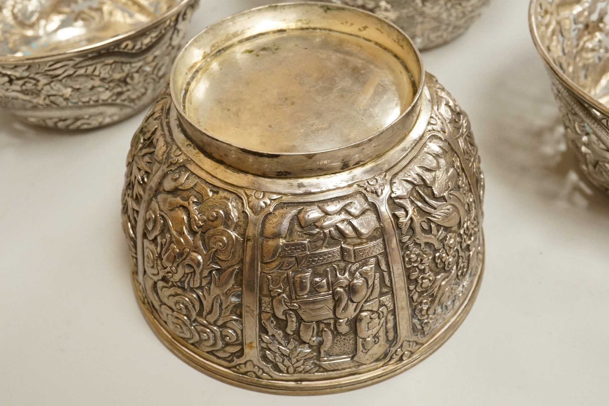 A set of three late 19th/early 20th century Chinese Export pierced white metal bowls, decorated with dragons, by Wang Hing, Hong Kong (lacking glass inserts?), diameter 12.5cm, together with one other similar Chinese Exp